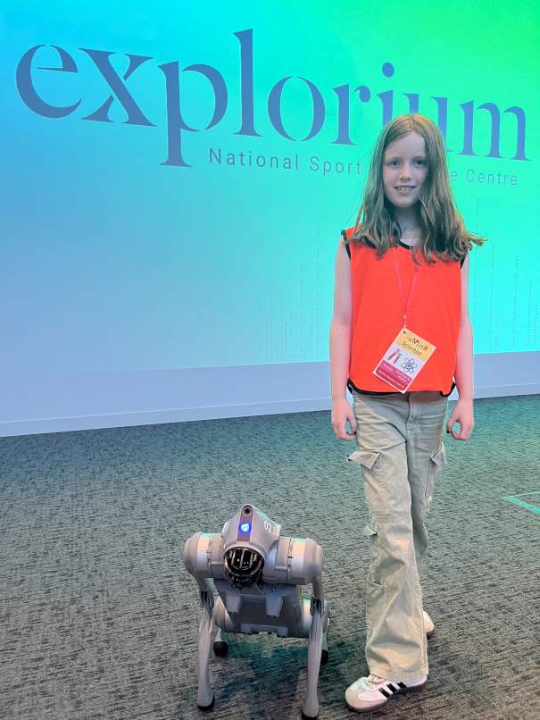 Children watching the robotic dog demonstration and learning about robotics