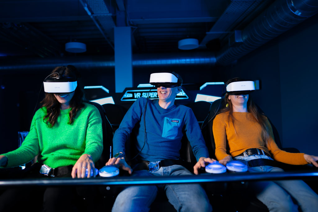 People enjoying a virtual reality gaming experience wearing VR headsets in a futuristic setting.