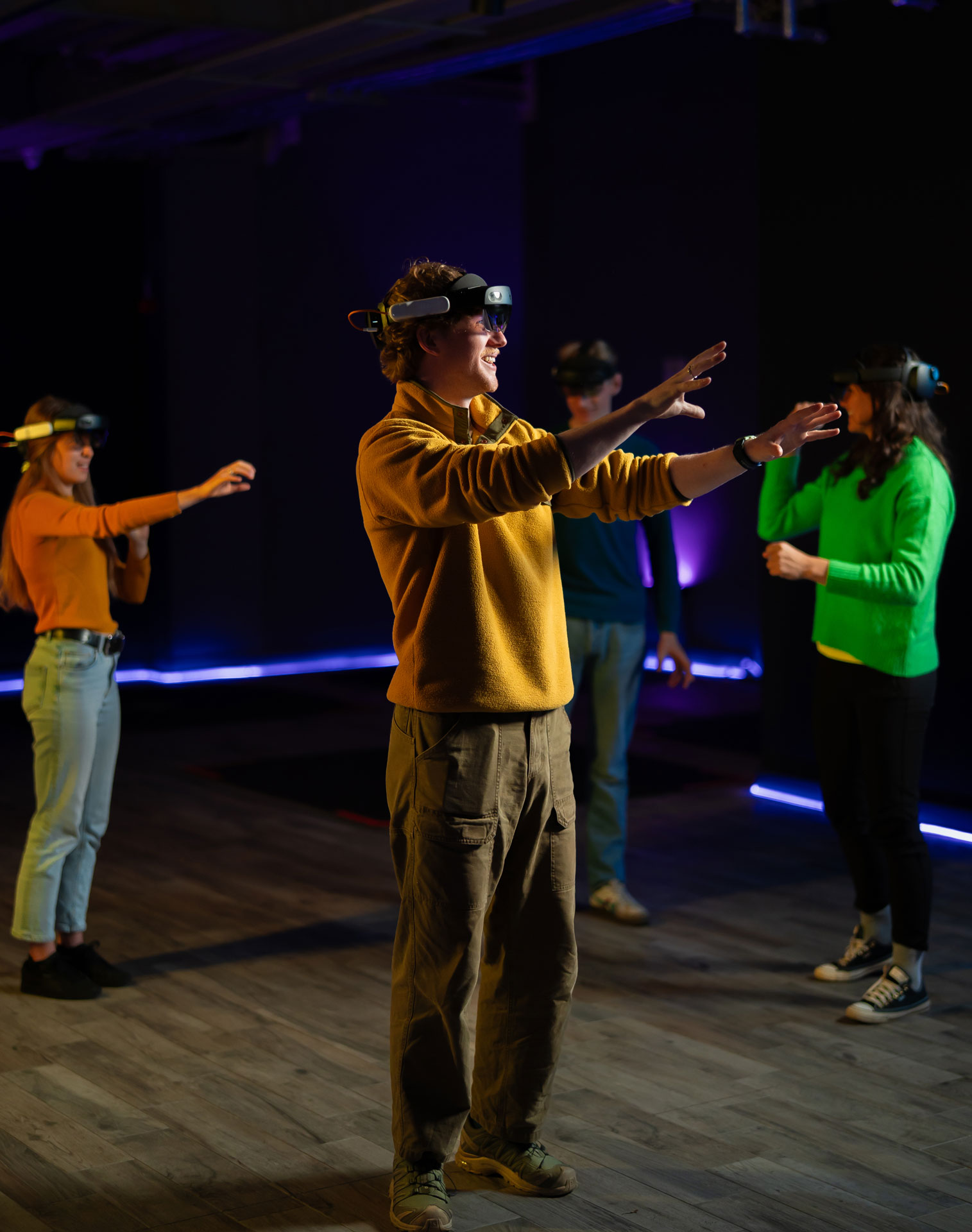 Group enjoying a virtual reality experience together, wearing headsets in a dimly lit room.