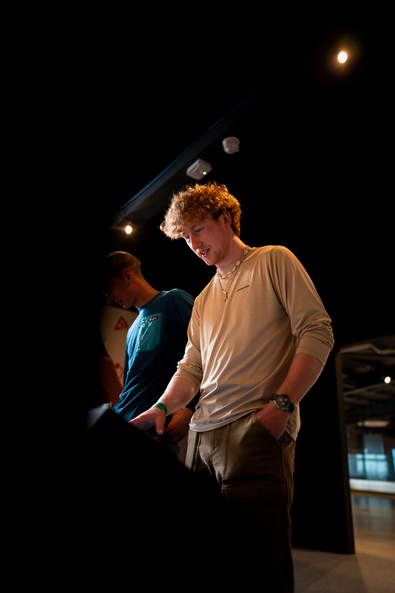 Two individuals looking at a display in a dimly lit room, engaged and focused on the task at hand.